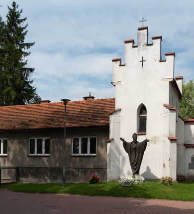 Zdjęcie nr 58: Kościół orientowany, murowany z cegły i kamienia, jednonawowy z trójprzęsłowym prezbiterium zamkniętym wielobocznie, sklepionym krzyżowo-żebrowo. Od północy umieszczona prostokątna, piętrowa zakrystia sklepiona kolebkowo (pięterko nad zakrystią dodane w 1885), dostępna kamiennym portalem o wykroju prostokątnym od strony wschodniej. Ściana północna zakrystii zakończona schodkowo z dekoracją blendową. Również od północy, na szerokości nawy do kościoła przylega prostokątna kaplica nakryta dachem czterospadowym zwieńczonym czworoboczną wieżyczką dostępna od zachodu przez prostokątną kruchtę z portalem o wykroju prostokątnym ujętym dwulalkowymi, kamiennymi balaskami. Kruchta zwieńczona trójkątnym przyczółkiem, na którym kamienny krzyż. Trójprzęsłowa nawa wyższa i szersza od prezbiterium i przesunięta w stosunku do jego osi ku stronie północnej, nakryta stropem. Północny mur nawy w części zachodniej poszerzony do pewnej wysokości dla pomieszczenia w jego grubości schodów prowadzących na chór muzyczny. Okna prostokątne zamknięte łukiem półkolistym. Zachodni i wschodni szczyt nawy zamknięty schodkowo. Od strony wschodniej trzy ostrołukowe blendy, w środkowej, wyżej od bocznych umieszczona tarcza herbowa z wizerunkiem św. Stanisława oraz Orła Białego. Od południa do nawy przylega prostokątna kruchta z kamiennym, ostrołukowym portalem nakryta dachem pulpitowym. Od strony zachodniej do bryły kościoła dostawiona prostokątna, współczesna kruchta wraz z chórem muzycznym (dobudowana w 1966) dostępna portalem o wykroju prostokątnym, nakryta dwuspadowym dachem. W ścianach bocznych wąskie, smukłe okna w kształcie stojącego prostokąta. Ponad kruchtą ażurowa dzwonnica na rzucie trójkąta zwieńczona krzyżem. Wieżyczka na sygnaturkę na rzucie ośmioboku zwieńczona barokowym hełmem z glorietą i krzyżem. Od zewnątrz kościół częściowo tynkowany, nawa i prezbiterium opięte szkarpami. Dachy kryte dachówką oraz blachą (część wschodnia prezbiterium).