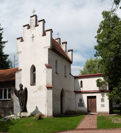Zdjęcie nr 5: Kościół orientowany, murowany z cegły i kamienia, jednonawowy z trójprzęsłowym prezbiterium zamkniętym wielobocznie, sklepionym krzyżowo-żebrowo. Od północy umieszczona prostokątna, piętrowa zakrystia sklepiona kolebkowo (pięterko nad zakrystią dodane w 1885), dostępna kamiennym portalem o wykroju prostokątnym od strony wschodniej. Ściana północna zakrystii zakończona schodkowo z dekoracją blendową. Również od północy, na szerokości nawy do kościoła przylega prostokątna kaplica nakryta dachem czterospadowym zwieńczonym czworoboczną wieżyczką dostępna od zachodu przez prostokątną kruchtę z portalem o wykroju prostokątnym ujętym dwulalkowymi, kamiennymi balaskami. Kruchta zwieńczona trójkątnym przyczółkiem, na którym kamienny krzyż. Trójprzęsłowa nawa wyższa i szersza od prezbiterium i przesunięta w stosunku do jego osi ku stronie północnej, nakryta stropem. Północny mur nawy w części zachodniej poszerzony do pewnej wysokości dla pomieszczenia w jego grubości schodów prowadzących na chór muzyczny. Okna prostokątne zamknięte łukiem półkolistym. Zachodni i wschodni szczyt nawy zamknięty schodkowo. Od strony wschodniej trzy ostrołukowe blendy, w środkowej, wyżej od bocznych umieszczona tarcza herbowa z wizerunkiem św. Stanisława oraz Orła Białego. Od południa do nawy przylega prostokątna kruchta z kamiennym, ostrołukowym portalem nakryta dachem pulpitowym. Od strony zachodniej do bryły kościoła dostawiona prostokątna, współczesna kruchta wraz z chórem muzycznym (dobudowana w 1966) dostępna portalem o wykroju prostokątnym, nakryta dwuspadowym dachem. W ścianach bocznych wąskie, smukłe okna w kształcie stojącego prostokąta. Ponad kruchtą ażurowa dzwonnica na rzucie trójkąta zwieńczona krzyżem. Wieżyczka na sygnaturkę na rzucie ośmioboku zwieńczona barokowym hełmem z glorietą i krzyżem. Od zewnątrz kościół częściowo tynkowany, nawa i prezbiterium opięte szkarpami. Dachy kryte dachówką oraz blachą (część wschodnia prezbiterium).