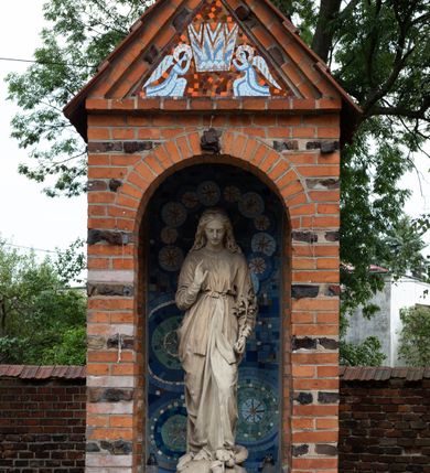 Zdjęcie nr 10: Kościół orientowany, murowany z cegły i kamienia, jednonawowy z trójprzęsłowym prezbiterium zamkniętym wielobocznie, sklepionym krzyżowo-żebrowo. Od północy umieszczona prostokątna, piętrowa zakrystia sklepiona kolebkowo (pięterko nad zakrystią dodane w 1885), dostępna kamiennym portalem o wykroju prostokątnym od strony wschodniej. Ściana północna zakrystii zakończona schodkowo z dekoracją blendową. Również od północy, na szerokości nawy do kościoła przylega prostokątna kaplica nakryta dachem czterospadowym zwieńczonym czworoboczną wieżyczką dostępna od zachodu przez prostokątną kruchtę z portalem o wykroju prostokątnym ujętym dwulalkowymi, kamiennymi balaskami. Kruchta zwieńczona trójkątnym przyczółkiem, na którym kamienny krzyż. Trójprzęsłowa nawa wyższa i szersza od prezbiterium i przesunięta w stosunku do jego osi ku stronie północnej, nakryta stropem. Północny mur nawy w części zachodniej poszerzony do pewnej wysokości dla pomieszczenia w jego grubości schodów prowadzących na chór muzyczny. Okna prostokątne zamknięte łukiem półkolistym. Zachodni i wschodni szczyt nawy zamknięty schodkowo. Od strony wschodniej trzy ostrołukowe blendy, w środkowej, wyżej od bocznych umieszczona tarcza herbowa z wizerunkiem św. Stanisława oraz Orła Białego. Od południa do nawy przylega prostokątna kruchta z kamiennym, ostrołukowym portalem nakryta dachem pulpitowym. Od strony zachodniej do bryły kościoła dostawiona prostokątna, współczesna kruchta wraz z chórem muzycznym (dobudowana w 1966) dostępna portalem o wykroju prostokątnym, nakryta dwuspadowym dachem. W ścianach bocznych wąskie, smukłe okna w kształcie stojącego prostokąta. Ponad kruchtą ażurowa dzwonnica na rzucie trójkąta zwieńczona krzyżem. Wieżyczka na sygnaturkę na rzucie ośmioboku zwieńczona barokowym hełmem z glorietą i krzyżem. Od zewnątrz kościół częściowo tynkowany, nawa i prezbiterium opięte szkarpami. Dachy kryte dachówką oraz blachą (część wschodnia prezbiterium).