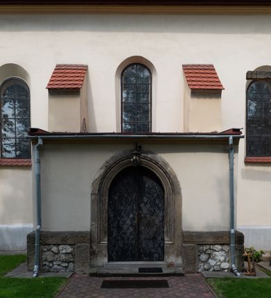 Zdjęcie nr 22: Kościół orientowany, murowany z cegły i kamienia, jednonawowy z trójprzęsłowym prezbiterium zamkniętym wielobocznie, sklepionym krzyżowo-żebrowo. Od północy umieszczona prostokątna, piętrowa zakrystia sklepiona kolebkowo (pięterko nad zakrystią dodane w 1885), dostępna kamiennym portalem o wykroju prostokątnym od strony wschodniej. Ściana północna zakrystii zakończona schodkowo z dekoracją blendową. Również od północy, na szerokości nawy do kościoła przylega prostokątna kaplica nakryta dachem czterospadowym zwieńczonym czworoboczną wieżyczką dostępna od zachodu przez prostokątną kruchtę z portalem o wykroju prostokątnym ujętym dwulalkowymi, kamiennymi balaskami. Kruchta zwieńczona trójkątnym przyczółkiem, na którym kamienny krzyż. Trójprzęsłowa nawa wyższa i szersza od prezbiterium i przesunięta w stosunku do jego osi ku stronie północnej, nakryta stropem. Północny mur nawy w części zachodniej poszerzony do pewnej wysokości dla pomieszczenia w jego grubości schodów prowadzących na chór muzyczny. Okna prostokątne zamknięte łukiem półkolistym. Zachodni i wschodni szczyt nawy zamknięty schodkowo. Od strony wschodniej trzy ostrołukowe blendy, w środkowej, wyżej od bocznych umieszczona tarcza herbowa z wizerunkiem św. Stanisława oraz Orła Białego. Od południa do nawy przylega prostokątna kruchta z kamiennym, ostrołukowym portalem nakryta dachem pulpitowym. Od strony zachodniej do bryły kościoła dostawiona prostokątna, współczesna kruchta wraz z chórem muzycznym (dobudowana w 1966) dostępna portalem o wykroju prostokątnym, nakryta dwuspadowym dachem. W ścianach bocznych wąskie, smukłe okna w kształcie stojącego prostokąta. Ponad kruchtą ażurowa dzwonnica na rzucie trójkąta zwieńczona krzyżem. Wieżyczka na sygnaturkę na rzucie ośmioboku zwieńczona barokowym hełmem z glorietą i krzyżem. Od zewnątrz kościół częściowo tynkowany, nawa i prezbiterium opięte szkarpami. Dachy kryte dachówką oraz blachą (część wschodnia prezbiterium).