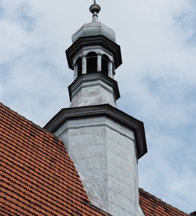 Zdjęcie nr 23: Kościół orientowany, murowany z cegły i kamienia, jednonawowy z trójprzęsłowym prezbiterium zamkniętym wielobocznie, sklepionym krzyżowo-żebrowo. Od północy umieszczona prostokątna, piętrowa zakrystia sklepiona kolebkowo (pięterko nad zakrystią dodane w 1885), dostępna kamiennym portalem o wykroju prostokątnym od strony wschodniej. Ściana północna zakrystii zakończona schodkowo z dekoracją blendową. Również od północy, na szerokości nawy do kościoła przylega prostokątna kaplica nakryta dachem czterospadowym zwieńczonym czworoboczną wieżyczką dostępna od zachodu przez prostokątną kruchtę z portalem o wykroju prostokątnym ujętym dwulalkowymi, kamiennymi balaskami. Kruchta zwieńczona trójkątnym przyczółkiem, na którym kamienny krzyż. Trójprzęsłowa nawa wyższa i szersza od prezbiterium i przesunięta w stosunku do jego osi ku stronie północnej, nakryta stropem. Północny mur nawy w części zachodniej poszerzony do pewnej wysokości dla pomieszczenia w jego grubości schodów prowadzących na chór muzyczny. Okna prostokątne zamknięte łukiem półkolistym. Zachodni i wschodni szczyt nawy zamknięty schodkowo. Od strony wschodniej trzy ostrołukowe blendy, w środkowej, wyżej od bocznych umieszczona tarcza herbowa z wizerunkiem św. Stanisława oraz Orła Białego. Od południa do nawy przylega prostokątna kruchta z kamiennym, ostrołukowym portalem nakryta dachem pulpitowym. Od strony zachodniej do bryły kościoła dostawiona prostokątna, współczesna kruchta wraz z chórem muzycznym (dobudowana w 1966) dostępna portalem o wykroju prostokątnym, nakryta dwuspadowym dachem. W ścianach bocznych wąskie, smukłe okna w kształcie stojącego prostokąta. Ponad kruchtą ażurowa dzwonnica na rzucie trójkąta zwieńczona krzyżem. Wieżyczka na sygnaturkę na rzucie ośmioboku zwieńczona barokowym hełmem z glorietą i krzyżem. Od zewnątrz kościół częściowo tynkowany, nawa i prezbiterium opięte szkarpami. Dachy kryte dachówką oraz blachą (część wschodnia prezbiterium).