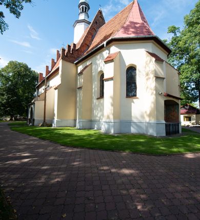 Zdjęcie nr 31: Kościół orientowany, murowany z cegły i kamienia, jednonawowy z trójprzęsłowym prezbiterium zamkniętym wielobocznie, sklepionym krzyżowo-żebrowo. Od północy umieszczona prostokątna, piętrowa zakrystia sklepiona kolebkowo (pięterko nad zakrystią dodane w 1885), dostępna kamiennym portalem o wykroju prostokątnym od strony wschodniej. Ściana północna zakrystii zakończona schodkowo z dekoracją blendową. Również od północy, na szerokości nawy do kościoła przylega prostokątna kaplica nakryta dachem czterospadowym zwieńczonym czworoboczną wieżyczką dostępna od zachodu przez prostokątną kruchtę z portalem o wykroju prostokątnym ujętym dwulalkowymi, kamiennymi balaskami. Kruchta zwieńczona trójkątnym przyczółkiem, na którym kamienny krzyż. Trójprzęsłowa nawa wyższa i szersza od prezbiterium i przesunięta w stosunku do jego osi ku stronie północnej, nakryta stropem. Północny mur nawy w części zachodniej poszerzony do pewnej wysokości dla pomieszczenia w jego grubości schodów prowadzących na chór muzyczny. Okna prostokątne zamknięte łukiem półkolistym. Zachodni i wschodni szczyt nawy zamknięty schodkowo. Od strony wschodniej trzy ostrołukowe blendy, w środkowej, wyżej od bocznych umieszczona tarcza herbowa z wizerunkiem św. Stanisława oraz Orła Białego. Od południa do nawy przylega prostokątna kruchta z kamiennym, ostrołukowym portalem nakryta dachem pulpitowym. Od strony zachodniej do bryły kościoła dostawiona prostokątna, współczesna kruchta wraz z chórem muzycznym (dobudowana w 1966) dostępna portalem o wykroju prostokątnym, nakryta dwuspadowym dachem. W ścianach bocznych wąskie, smukłe okna w kształcie stojącego prostokąta. Ponad kruchtą ażurowa dzwonnica na rzucie trójkąta zwieńczona krzyżem. Wieżyczka na sygnaturkę na rzucie ośmioboku zwieńczona barokowym hełmem z glorietą i krzyżem. Od zewnątrz kościół częściowo tynkowany, nawa i prezbiterium opięte szkarpami. Dachy kryte dachówką oraz blachą (część wschodnia prezbiterium).