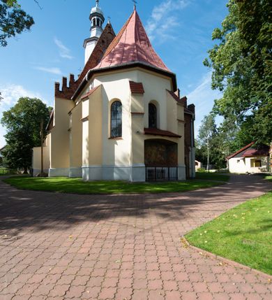 Zdjęcie nr 34: Kościół orientowany, murowany z cegły i kamienia, jednonawowy z trójprzęsłowym prezbiterium zamkniętym wielobocznie, sklepionym krzyżowo-żebrowo. Od północy umieszczona prostokątna, piętrowa zakrystia sklepiona kolebkowo (pięterko nad zakrystią dodane w 1885), dostępna kamiennym portalem o wykroju prostokątnym od strony wschodniej. Ściana północna zakrystii zakończona schodkowo z dekoracją blendową. Również od północy, na szerokości nawy do kościoła przylega prostokątna kaplica nakryta dachem czterospadowym zwieńczonym czworoboczną wieżyczką dostępna od zachodu przez prostokątną kruchtę z portalem o wykroju prostokątnym ujętym dwulalkowymi, kamiennymi balaskami. Kruchta zwieńczona trójkątnym przyczółkiem, na którym kamienny krzyż. Trójprzęsłowa nawa wyższa i szersza od prezbiterium i przesunięta w stosunku do jego osi ku stronie północnej, nakryta stropem. Północny mur nawy w części zachodniej poszerzony do pewnej wysokości dla pomieszczenia w jego grubości schodów prowadzących na chór muzyczny. Okna prostokątne zamknięte łukiem półkolistym. Zachodni i wschodni szczyt nawy zamknięty schodkowo. Od strony wschodniej trzy ostrołukowe blendy, w środkowej, wyżej od bocznych umieszczona tarcza herbowa z wizerunkiem św. Stanisława oraz Orła Białego. Od południa do nawy przylega prostokątna kruchta z kamiennym, ostrołukowym portalem nakryta dachem pulpitowym. Od strony zachodniej do bryły kościoła dostawiona prostokątna, współczesna kruchta wraz z chórem muzycznym (dobudowana w 1966) dostępna portalem o wykroju prostokątnym, nakryta dwuspadowym dachem. W ścianach bocznych wąskie, smukłe okna w kształcie stojącego prostokąta. Ponad kruchtą ażurowa dzwonnica na rzucie trójkąta zwieńczona krzyżem. Wieżyczka na sygnaturkę na rzucie ośmioboku zwieńczona barokowym hełmem z glorietą i krzyżem. Od zewnątrz kościół częściowo tynkowany, nawa i prezbiterium opięte szkarpami. Dachy kryte dachówką oraz blachą (część wschodnia prezbiterium).