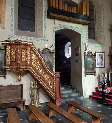 Zdjęcie nr 35: Kościół orientowany, murowany z cegły i kamienia, jednonawowy z trójprzęsłowym prezbiterium zamkniętym wielobocznie, sklepionym krzyżowo-żebrowo. Od północy umieszczona prostokątna, piętrowa zakrystia sklepiona kolebkowo (pięterko nad zakrystią dodane w 1885), dostępna kamiennym portalem o wykroju prostokątnym od strony wschodniej. Ściana północna zakrystii zakończona schodkowo z dekoracją blendową. Również od północy, na szerokości nawy do kościoła przylega prostokątna kaplica nakryta dachem czterospadowym zwieńczonym czworoboczną wieżyczką dostępna od zachodu przez prostokątną kruchtę z portalem o wykroju prostokątnym ujętym dwulalkowymi, kamiennymi balaskami. Kruchta zwieńczona trójkątnym przyczółkiem, na którym kamienny krzyż. Trójprzęsłowa nawa wyższa i szersza od prezbiterium i przesunięta w stosunku do jego osi ku stronie północnej, nakryta stropem. Północny mur nawy w części zachodniej poszerzony do pewnej wysokości dla pomieszczenia w jego grubości schodów prowadzących na chór muzyczny. Okna prostokątne zamknięte łukiem półkolistym. Zachodni i wschodni szczyt nawy zamknięty schodkowo. Od strony wschodniej trzy ostrołukowe blendy, w środkowej, wyżej od bocznych umieszczona tarcza herbowa z wizerunkiem św. Stanisława oraz Orła Białego. Od południa do nawy przylega prostokątna kruchta z kamiennym, ostrołukowym portalem nakryta dachem pulpitowym. Od strony zachodniej do bryły kościoła dostawiona prostokątna, współczesna kruchta wraz z chórem muzycznym (dobudowana w 1966) dostępna portalem o wykroju prostokątnym, nakryta dwuspadowym dachem. W ścianach bocznych wąskie, smukłe okna w kształcie stojącego prostokąta. Ponad kruchtą ażurowa dzwonnica na rzucie trójkąta zwieńczona krzyżem. Wieżyczka na sygnaturkę na rzucie ośmioboku zwieńczona barokowym hełmem z glorietą i krzyżem. Od zewnątrz kościół częściowo tynkowany, nawa i prezbiterium opięte szkarpami. Dachy kryte dachówką oraz blachą (część wschodnia prezbiterium).