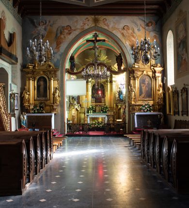Zdjęcie nr 38: Kościół orientowany, murowany z cegły i kamienia, jednonawowy z trójprzęsłowym prezbiterium zamkniętym wielobocznie, sklepionym krzyżowo-żebrowo. Od północy umieszczona prostokątna, piętrowa zakrystia sklepiona kolebkowo (pięterko nad zakrystią dodane w 1885), dostępna kamiennym portalem o wykroju prostokątnym od strony wschodniej. Ściana północna zakrystii zakończona schodkowo z dekoracją blendową. Również od północy, na szerokości nawy do kościoła przylega prostokątna kaplica nakryta dachem czterospadowym zwieńczonym czworoboczną wieżyczką dostępna od zachodu przez prostokątną kruchtę z portalem o wykroju prostokątnym ujętym dwulalkowymi, kamiennymi balaskami. Kruchta zwieńczona trójkątnym przyczółkiem, na którym kamienny krzyż. Trójprzęsłowa nawa wyższa i szersza od prezbiterium i przesunięta w stosunku do jego osi ku stronie północnej, nakryta stropem. Północny mur nawy w części zachodniej poszerzony do pewnej wysokości dla pomieszczenia w jego grubości schodów prowadzących na chór muzyczny. Okna prostokątne zamknięte łukiem półkolistym. Zachodni i wschodni szczyt nawy zamknięty schodkowo. Od strony wschodniej trzy ostrołukowe blendy, w środkowej, wyżej od bocznych umieszczona tarcza herbowa z wizerunkiem św. Stanisława oraz Orła Białego. Od południa do nawy przylega prostokątna kruchta z kamiennym, ostrołukowym portalem nakryta dachem pulpitowym. Od strony zachodniej do bryły kościoła dostawiona prostokątna, współczesna kruchta wraz z chórem muzycznym (dobudowana w 1966) dostępna portalem o wykroju prostokątnym, nakryta dwuspadowym dachem. W ścianach bocznych wąskie, smukłe okna w kształcie stojącego prostokąta. Ponad kruchtą ażurowa dzwonnica na rzucie trójkąta zwieńczona krzyżem. Wieżyczka na sygnaturkę na rzucie ośmioboku zwieńczona barokowym hełmem z glorietą i krzyżem. Od zewnątrz kościół częściowo tynkowany, nawa i prezbiterium opięte szkarpami. Dachy kryte dachówką oraz blachą (część wschodnia prezbiterium).