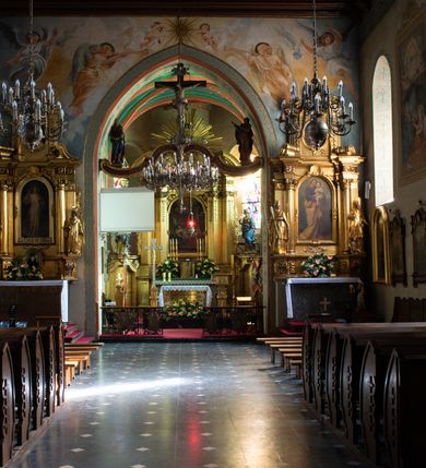 Zdjęcie nr 41: Kościół orientowany, murowany z cegły i kamienia, jednonawowy z trójprzęsłowym prezbiterium zamkniętym wielobocznie, sklepionym krzyżowo-żebrowo. Od północy umieszczona prostokątna, piętrowa zakrystia sklepiona kolebkowo (pięterko nad zakrystią dodane w 1885), dostępna kamiennym portalem o wykroju prostokątnym od strony wschodniej. Ściana północna zakrystii zakończona schodkowo z dekoracją blendową. Również od północy, na szerokości nawy do kościoła przylega prostokątna kaplica nakryta dachem czterospadowym zwieńczonym czworoboczną wieżyczką dostępna od zachodu przez prostokątną kruchtę z portalem o wykroju prostokątnym ujętym dwulalkowymi, kamiennymi balaskami. Kruchta zwieńczona trójkątnym przyczółkiem, na którym kamienny krzyż. Trójprzęsłowa nawa wyższa i szersza od prezbiterium i przesunięta w stosunku do jego osi ku stronie północnej, nakryta stropem. Północny mur nawy w części zachodniej poszerzony do pewnej wysokości dla pomieszczenia w jego grubości schodów prowadzących na chór muzyczny. Okna prostokątne zamknięte łukiem półkolistym. Zachodni i wschodni szczyt nawy zamknięty schodkowo. Od strony wschodniej trzy ostrołukowe blendy, w środkowej, wyżej od bocznych umieszczona tarcza herbowa z wizerunkiem św. Stanisława oraz Orła Białego. Od południa do nawy przylega prostokątna kruchta z kamiennym, ostrołukowym portalem nakryta dachem pulpitowym. Od strony zachodniej do bryły kościoła dostawiona prostokątna, współczesna kruchta wraz z chórem muzycznym (dobudowana w 1966) dostępna portalem o wykroju prostokątnym, nakryta dwuspadowym dachem. W ścianach bocznych wąskie, smukłe okna w kształcie stojącego prostokąta. Ponad kruchtą ażurowa dzwonnica na rzucie trójkąta zwieńczona krzyżem. Wieżyczka na sygnaturkę na rzucie ośmioboku zwieńczona barokowym hełmem z glorietą i krzyżem. Od zewnątrz kościół częściowo tynkowany, nawa i prezbiterium opięte szkarpami. Dachy kryte dachówką oraz blachą (część wschodnia prezbiterium).