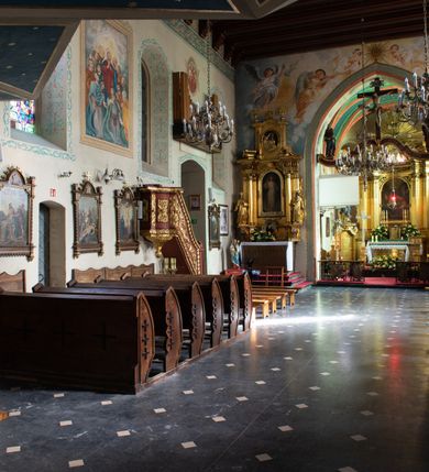 Zdjęcie nr 46: Kościół orientowany, murowany z cegły i kamienia, jednonawowy z trójprzęsłowym prezbiterium zamkniętym wielobocznie, sklepionym krzyżowo-żebrowo. Od północy umieszczona prostokątna, piętrowa zakrystia sklepiona kolebkowo (pięterko nad zakrystią dodane w 1885), dostępna kamiennym portalem o wykroju prostokątnym od strony wschodniej. Ściana północna zakrystii zakończona schodkowo z dekoracją blendową. Również od północy, na szerokości nawy do kościoła przylega prostokątna kaplica nakryta dachem czterospadowym zwieńczonym czworoboczną wieżyczką dostępna od zachodu przez prostokątną kruchtę z portalem o wykroju prostokątnym ujętym dwulalkowymi, kamiennymi balaskami. Kruchta zwieńczona trójkątnym przyczółkiem, na którym kamienny krzyż. Trójprzęsłowa nawa wyższa i szersza od prezbiterium i przesunięta w stosunku do jego osi ku stronie północnej, nakryta stropem. Północny mur nawy w części zachodniej poszerzony do pewnej wysokości dla pomieszczenia w jego grubości schodów prowadzących na chór muzyczny. Okna prostokątne zamknięte łukiem półkolistym. Zachodni i wschodni szczyt nawy zamknięty schodkowo. Od strony wschodniej trzy ostrołukowe blendy, w środkowej, wyżej od bocznych umieszczona tarcza herbowa z wizerunkiem św. Stanisława oraz Orła Białego. Od południa do nawy przylega prostokątna kruchta z kamiennym, ostrołukowym portalem nakryta dachem pulpitowym. Od strony zachodniej do bryły kościoła dostawiona prostokątna, współczesna kruchta wraz z chórem muzycznym (dobudowana w 1966) dostępna portalem o wykroju prostokątnym, nakryta dwuspadowym dachem. W ścianach bocznych wąskie, smukłe okna w kształcie stojącego prostokąta. Ponad kruchtą ażurowa dzwonnica na rzucie trójkąta zwieńczona krzyżem. Wieżyczka na sygnaturkę na rzucie ośmioboku zwieńczona barokowym hełmem z glorietą i krzyżem. Od zewnątrz kościół częściowo tynkowany, nawa i prezbiterium opięte szkarpami. Dachy kryte dachówką oraz blachą (część wschodnia prezbiterium).