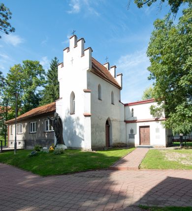 Zdjęcie nr 47: Kościół orientowany, murowany z cegły i kamienia, jednonawowy z trójprzęsłowym prezbiterium zamkniętym wielobocznie, sklepionym krzyżowo-żebrowo. Od północy umieszczona prostokątna, piętrowa zakrystia sklepiona kolebkowo (pięterko nad zakrystią dodane w 1885), dostępna kamiennym portalem o wykroju prostokątnym od strony wschodniej. Ściana północna zakrystii zakończona schodkowo z dekoracją blendową. Również od północy, na szerokości nawy do kościoła przylega prostokątna kaplica nakryta dachem czterospadowym zwieńczonym czworoboczną wieżyczką dostępna od zachodu przez prostokątną kruchtę z portalem o wykroju prostokątnym ujętym dwulalkowymi, kamiennymi balaskami. Kruchta zwieńczona trójkątnym przyczółkiem, na którym kamienny krzyż. Trójprzęsłowa nawa wyższa i szersza od prezbiterium i przesunięta w stosunku do jego osi ku stronie północnej, nakryta stropem. Północny mur nawy w części zachodniej poszerzony do pewnej wysokości dla pomieszczenia w jego grubości schodów prowadzących na chór muzyczny. Okna prostokątne zamknięte łukiem półkolistym. Zachodni i wschodni szczyt nawy zamknięty schodkowo. Od strony wschodniej trzy ostrołukowe blendy, w środkowej, wyżej od bocznych umieszczona tarcza herbowa z wizerunkiem św. Stanisława oraz Orła Białego. Od południa do nawy przylega prostokątna kruchta z kamiennym, ostrołukowym portalem nakryta dachem pulpitowym. Od strony zachodniej do bryły kościoła dostawiona prostokątna, współczesna kruchta wraz z chórem muzycznym (dobudowana w 1966) dostępna portalem o wykroju prostokątnym, nakryta dwuspadowym dachem. W ścianach bocznych wąskie, smukłe okna w kształcie stojącego prostokąta. Ponad kruchtą ażurowa dzwonnica na rzucie trójkąta zwieńczona krzyżem. Wieżyczka na sygnaturkę na rzucie ośmioboku zwieńczona barokowym hełmem z glorietą i krzyżem. Od zewnątrz kościół częściowo tynkowany, nawa i prezbiterium opięte szkarpami. Dachy kryte dachówką oraz blachą (część wschodnia prezbiterium).