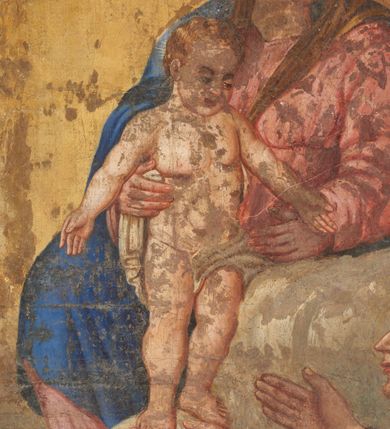 Zdjęcie nr 5: Obraz w kształcie stojącego prostokąta zamkniętego trapezoidalnie. Św. Antoni Padewski ukazany z profilu w pozycji klęczącej, przyklęka na lewe kolano, z rękami lekko zgiętymi w łokciach, uniesionymi ku górze. Twarz ukazana z profilu, uniesiona ku górze. Święty odziany w ciemnobrązowy habit franciszkański, przewiazany szarym sznurem, do którego przywiazany jest różaniec. Św. Antoni dotyka lewą dłonią stopy stojacego przed nim Dzieciątka Jezus, podtrzymywanego przez wyłaniającą się z chmur Matkę Boską. Maria ukazana w pozycji siedzącej, zwrócona lekko, w ¾ w kierunku świętego. Odziana w jasno czerwoną suknię i niebieski płaszcz. Przed Św. Antonim stolik, nakryty czerwoną tkaniną, na którym widoczna jest czaszka, otwarta księga i lilia. Za postacią świętego szara kolumna z kotarą w kolorze ciemnej zieleni ze złota lamówką. Tło utrzymane w ciepłej tonacji – w dolnej partii pola obrazowego beżowo – brązowe, w górnej – szarożółte.