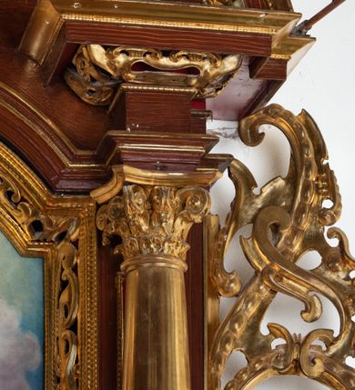 Zdjęcie nr 13: Ołtarz architektoniczny, dwukondygnacyjny, jednoosiowy ze zwieńczeniem. Mensa prostopadłościenna, antepedium w kształcie leżącego prostokąta, flankowane dwoma kanelowanymi pilastrami. W polu płycina w kształcie leżącego prostokąta wypełniona symetryczną dekoracją z akantu na czerwonym tle z sercem przebitym mieczem pośrodku. Cokół nastawy ustawiony na jednym stopniu, pośrodku zdobiony płyciną w kształcie leżącego prostokąta o zaokrąglonych krótszych bokach, cokoły pod kolumnami dekorowane mniejszymi płycinami wypełnionymi dekoracją roślinną. Pierwsza kondygnacja ujęta parą kolumn dźwigających przerwane belkowanie z przyczółkami, po bokach dodatkowo flankowana uszami wykończonymi ornamentem małżowinowo-chrząstkowym. W polu głównym obraz Najświętsze Serce Jezusa. Po bokach nastawy dwie rzeźby: po prawej św. Kazimierz Królewicz, a po lewej św. Alojzy Gonzaga. Na przyczółkach usadzone dwie rzeźby aniołów z rozłożonymi szeroko rękami. Kolumny ustawione na tle prostokątnych płycin, z bazami, trzony gładkie, kapitele kompozytowe. Druga kondygnacja flankowana parą kolumn podtrzymujących wyłamane belkowanie. W polu, w ramie o kształcie stojącego prostokąta o ściętych narożach obraz św. Michała Archanioła. W zwieńczeniu promienista gloria z monogramem Chrystusa na czerwonym tle, obwiedzionym wieńcem z obłoków. Zwieńczenie ujęte po bokach uszami. Struktura malowana w kolorze naturalnego drewna, ornamentyka złocona, detale srebrzone i czerwone.
