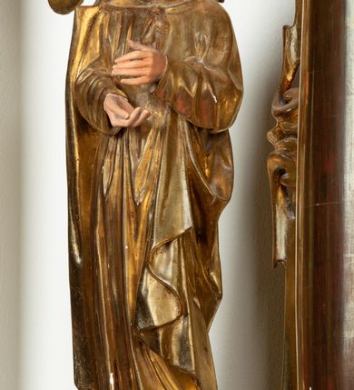 Zdjęcie nr 25: Ołtarz architektoniczny, dwukondygnacyjny, jednoosiowy ze zwieńczeniem. Mensa prostopadłościenna, antepedium w kształcie leżącego prostokąta, flankowane dwoma kanelowanymi pilastrami. W polu płycina w kształcie leżącego prostokąta wypełniona symetryczną dekoracją z akantu na czerwonym tle z sercem przebitym mieczem pośrodku. Cokół nastawy ustawiony na jednym stopniu, pośrodku zdobiony płyciną w kształcie leżącego prostokąta o zaokrąglonych krótszych bokach, cokoły pod kolumnami dekorowane mniejszymi płycinami wypełnionymi dekoracją roślinną. Pierwsza kondygnacja ujęta parą kolumn dźwigających przerwane belkowanie z przyczółkami, po bokach dodatkowo flankowana uszami wykończonymi ornamentem małżowinowo-chrząstkowym. W polu głównym obraz Najświętsze Serce Jezusa. Po bokach nastawy dwie rzeźby: po prawej św. Kazimierz Królewicz, a po lewej św. Alojzy Gonzaga. Na przyczółkach usadzone dwie rzeźby aniołów z rozłożonymi szeroko rękami. Kolumny ustawione na tle prostokątnych płycin, z bazami, trzony gładkie, kapitele kompozytowe. Druga kondygnacja flankowana parą kolumn podtrzymujących wyłamane belkowanie. W polu, w ramie o kształcie stojącego prostokąta o ściętych narożach obraz św. Michała Archanioła. W zwieńczeniu promienista gloria z monogramem Chrystusa na czerwonym tle, obwiedzionym wieńcem z obłoków. Zwieńczenie ujęte po bokach uszami. Struktura malowana w kolorze naturalnego drewna, ornamentyka złocona, detale srebrzone i czerwone.
