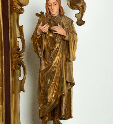 Zdjęcie nr 4: Ołtarz architektoniczny, dwukondygnacyjny, jednoosiowy ze zwieńczeniem. Mensa prostopadłościenna, antepedium w kształcie leżącego prostokąta, flankowane dwoma kanelowanymi pilastrami. W polu płycina w kształcie leżącego prostokąta wypełniona symetryczną dekoracją z akantu na czerwonym tle z sercem przebitym mieczem pośrodku. Cokół nastawy ustawiony na jednym stopniu, pośrodku zdobiony płyciną w kształcie leżącego prostokąta o zaokrąglonych krótszych bokach, cokoły pod kolumnami dekorowane mniejszymi płycinami wypełnionymi dekoracją roślinną. Pierwsza kondygnacja ujęta parą kolumn dźwigających przerwane belkowanie z przyczółkami, po bokach dodatkowo flankowana uszami wykończonymi ornamentem małżowinowo-chrząstkowym. W polu głównym obraz Najświętsze Serce Jezusa. Po bokach nastawy dwie rzeźby: po prawej św. Kazimierz Królewicz, a po lewej św. Alojzy Gonzaga. Na przyczółkach usadzone dwie rzeźby aniołów z rozłożonymi szeroko rękami. Kolumny ustawione na tle prostokątnych płycin, z bazami, trzony gładkie, kapitele kompozytowe. Druga kondygnacja flankowana parą kolumn podtrzymujących wyłamane belkowanie. W polu, w ramie o kształcie stojącego prostokąta o ściętych narożach obraz św. Michała Archanioła. W zwieńczeniu promienista gloria z monogramem Chrystusa na czerwonym tle, obwiedzionym wieńcem z obłoków. Zwieńczenie ujęte po bokach uszami. Struktura malowana w kolorze naturalnego drewna, ornamentyka złocona, detale srebrzone i czerwone.
