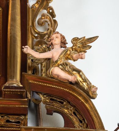 Zdjęcie nr 15: Ołtarz architektoniczny, dwukondygnacyjny, jednoosiowy ze zwieńczeniem. Mensa prostopadłościenna, antepedium w kształcie leżącego prostokąta, flankowane dwoma kanelowanymi pilastrami. W polu płycina w kształcie leżącego prostokąta wypełniona symetryczną dekoracją z akantu na czerwonym tle z sercem przebitym mieczem pośrodku. Cokół nastawy ustawiony na jednym stopniu, pośrodku zdobiony płyciną w kształcie leżącego prostokąta o zaokrąglonych krótszych bokach, cokoły pod kolumnami dekorowane mniejszymi płycinami wypełnionymi dekoracją roślinną. Pierwsza kondygnacja ujęta parą kolumn dźwigających przerwane belkowanie z przyczółkami, po bokach dodatkowo flankowana uszami wykończonymi ornamentem małżowinowo-chrząstkowym. W polu głównym obraz Najświętsze Serce Jezusa. Po bokach nastawy dwie rzeźby: po prawej św. Kazimierz Królewicz, a po lewej św. Alojzy Gonzaga. Na przyczółkach usadzone dwie rzeźby aniołów z rozłożonymi szeroko rękami. Kolumny ustawione na tle prostokątnych płycin, z bazami, trzony gładkie, kapitele kompozytowe. Druga kondygnacja flankowana parą kolumn podtrzymujących wyłamane belkowanie. W polu, w ramie o kształcie stojącego prostokąta o ściętych narożach obraz św. Michała Archanioła. W zwieńczeniu promienista gloria z monogramem Chrystusa na czerwonym tle, obwiedzionym wieńcem z obłoków. Zwieńczenie ujęte po bokach uszami. Struktura malowana w kolorze naturalnego drewna, ornamentyka złocona, detale srebrzone i czerwone.
