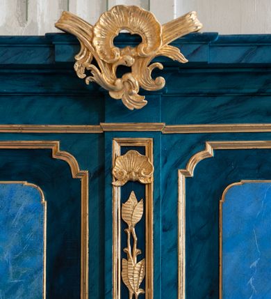 Zdjęcie nr 18: Dwie stalle o siedziskach obudowanych z przodu wybrzuszonymi ściankami z wazonami na pulpitach. Siedziska wybrzuszone z boku są ujęte falistymi poręczami, z plecami zdobionymi profilowanymi płycinami prostokątnymi o ściętych ćwierćkoliście narożach. Znajdujące się nad nimi wysokie zaplecki są ujęte pilastrami zdobionymi płycinami wypełnionymi wiciami liści i kwiatów z muszlami a z boku kampanuli, zwieńczone belkowaniem. W dwóch polach pomiędzy pilastrami zdwojone płyciny wyróżnione profilami w kształcie prostokątów o wyciętych ćwierćkoliście narożach.  Na belkowaniu trzy rokokowe kartusze i dwa płomieniste wazony. Polichromia imitująca jasno i ciemnoniebieską marmoryzację, ornamenty i profile złocone.  

Dwie stalle bez obudowy i wysokich zaplecków na falistych nogach, z których zewnętrzne poprzedzone lwimi łapami, z falistymi poręczami i prostymi oparciami zwieńczonymi gzymsem. Oparcie podzielone na trzy pola oddzielone żłobkowaniami i rautami nad nimi i wypełnione profilowanymi, kwadratowymi płycinami o ściętych ćwierćkoliście narożach.       