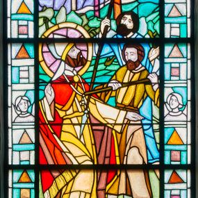 Zdjęcie nr 1: Witraż w kształcie stojącego prostokąta zamkniętego łukiem pełnym w szerokiej bordiurze wypełnionej popiersiami aniołów i figurami geometrycznymi. W centrum scena męczeństwa św. Wojciecha. Po lewej stronie święty w kontrapoście, z lewą ręką wyciągniętą przed siebie, prawą uniesioną i z głową odchyloną do tyłu. Na jego twarzy maluje się smutek, ma ciemną brodę i wąsy.  Jest ubrany w fioletową albę, żółtą komżę i obszerną czerwono-złotą kapę spiętą na piersiach. Na głowie ma mitrę, wokół głowy nimb. Po prawej stronie świetego dwóch mężczyzn. Stojący bliżej wbił włócznię w jego pierś świętego, dalszy kieruje swoją w stronę uda. Jeden jest ubrany w żółtą tunikę, drugi w niebieską, obaj mają gęste, brązowe włosy i brody. Za nimi abstrakcyjnie potraktowany krajobraz, żółto-zielony w dolnej partii i zielono-niebieski w górnej. W podłuczu napis „ŚW. WOJ/CIECH”  w otoczeniu różowo-pomarańczowo-czerwonych obłoków.  W partii bordiury, przy dolnej krawędzi kolejne „PROJ. /  BOLESŁAW SZPECHT / [...] / ZARZYCCY, KRAKÓW '99 (?)” oraz „FUNDACJA / DR STANISŁAW / SĘK”. 