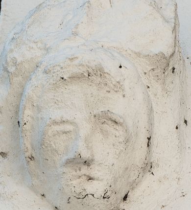 Zdjęcie nr 2: Wspornik w formie męskiej, owalnej twarzy, podtrzymującej półkolistą płytę. Twarz o zaznaczonych umownie oczodołach i łukach brwiowych, z wyodrębnionym krótkim nosem i szczeliną w miejscu ust; okolona krótkimi włosami, z grzywką nad czołem.



