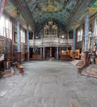 Zdjęcie nr 13: Kościół drewniany o konstrukcji zrębowej, elewacje jednolite, szalowane gontem. Wieża oraz kruchty zachodnia i południowa o konstrukcji słupowo-ramowej, kruchty szalowane deskami. Więźba dachowa drewniana, krokwiowa. Budynek na kamiennym podmurowaniu. 
Kościół orientowany, jednonawowy, nawa na rzucie prostokąta, prezbiterium węższe, wydłużone, zakończone trójbocznie. Do północnej ściany prezbiterium przylega zakrystia o wschodniej ścianie skośnej, będącej przedłużeniem bocznej ściany apsydy. 
Przy zachodniej ścianie nawy wieża na planie zbliżonym do kwadratu o wtórnym podziale na sale wystawiennicze (w przyziemiu wieży muzeum). Przy nawie od południa i przy wieży od frontu kruchty na planie kwadratu. 
Pomiędzy nawą a prezbiterium otwór tęczowy. 
Wnętrze nawy i prezbiterium nakryte pozornym sklepieniem kolebkowym, z zaskrzynieniami w nawie, podpartymi filarami o żłobkowanych trzonach, na cokołach, po trzy z każdej strony. Skrajem zaskrzynień nawy oraz górą ścian prezbiterium biegnie dekoracyjny gzyms drewniany, podparty w węgłach apsydy prezbiterialnej żłobkowanymi pilastrami. Łuk tęczowy półkolisty, wsparty na drewnianych konsolach. Otwory drzwiowe o prostokątnym wykroju zamknięte drzwiami obitymi deskami z metalowymi okuciami z prezbiterium do zakrystii, z nawy do kruchty południowej i z nawy do wieży. Okna w formie stojącego prostokąta zamkniętego łukiem odcinkowym, dwa w południowej ścianie prezbiterium, a w północnej dwa ślepe oraz cztery pary okien w północnej i południowej ścianie nawy. Na zamknięciu prezbiterium okulus z witrażem. Parapet chóru muzycznego w zachodniej części nawy, wsparty na dwóch drewnianych filarach, z wejściem z nawy po drabiniastych schodach z balustradą. Ściany i sklepienia pokryte polichromią z iluzjonistyczną architekturą i scenami figuralnymi. Posadzka kamienna.
Elewacja frontowa jednoosiowa. Na osi wejście do kruchty zachodniej. Korpus wieży o pochyłych ścianach, silnie zwężających się ku górze, zwieńczonych izbicą, ozdobioną u dołu koronką w formie zębów z frędzlami. Ściany kościoła, oprócz zakrystii i krucht szalowanych deskami, osłonięte rzędami gontów i opatrzone u dołu fartuchami. Na elewacji wschodniej ogrójec. 
Dach wyniosły, wspólny dla nawy i prezbiterium, hełm wieży cebulasty z latarnią, a w połowie długości dachu, nad nawą, wbudowana wieżyczka na sygnaturkę, wszystko kryte gontem. Kruchty nakryte osobnymi daszkami hełmowymi, baniastymi, krytymi gontem. 

Wokół kościoła rośnie starodrzew. Plac zamknięty kamiennym murem nakrytym drewnianym daszkiem dwuspadowym z 2 bramami i z 14 wieżyczkami (kapliczki-stacyjki) nakrytymi daszkami drewnianymi czterospadowymi. 