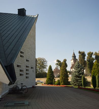 Zdjęcie nr 14: Budynek złożony z dwóch stopionych ze sobą brył, niższej o dwuspadowym dachu nakrywającym wnętrze prezbiterium i nawy oraz ostrosłupa wieży wpisanego w fasadę. Od strony prezbiterium dostawiona nieregularna bryła, niższa od kościoła, nakryta dwuspadowym dachem, mieszcząca zakrystię i kaplice Matki Boskiej. Połać dwustadowego dachu o nieregularnym, zygzakowatym konturze krawędzi, odsłaniającej przeszklone ściany, a miejscami sięgająca ziemi. Trójkątna w przekroju fasada z wieżą wpisaną w jej prawą połowę; lewa zaś w górnej połowie wypełniona witrażem, zamkniętym u dołu balkonem, nakrywającym przedsionek z wejściem do świątyni. Zewnętrzne elewacje kościoła pokryte są okładziną z wapienia pińczowskiego

Trójkątne w przekroju wnętrze podzielone na trzy nawy filarami. Prezbiterium zamknięte ścianą z wydzielonym trójkątem ołtarza głównego, złożonego z dwóch ścian pokrytych okładziną ceramiczną ustawionych pod kątem rozwartym, z otworem u szczytu na okno. Po przeciwnej stronie wnętrza wejście na wieżę i parapet chóru muzycznego. Na zakończeniu lewej nawy wejście do kaplicy Matki Boskiej, na zakończeniu prawej nawy zaaranżowana kaplica bł. Anieli Salawy. Ściany boczne całkowicie przeszklone; połowę przestrzeni fasady wypełnia witraż o polu w formie trójkąta o kącie prostym. W kaplicy Matki Boskiej otwory w formie szczelin oświetlające wnętrze umieszczone nieregularnie w polu ściany. 




