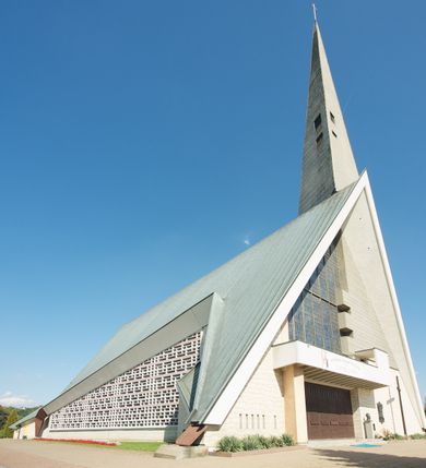 Zdjęcie nr 2: Budynek złożony z dwóch stopionych ze sobą brył, niższej o dwuspadowym dachu nakrywającym wnętrze prezbiterium i nawy oraz ostrosłupa wieży wpisanego w fasadę. Od strony prezbiterium dostawiona nieregularna bryła, niższa od kościoła, nakryta dwuspadowym dachem, mieszcząca zakrystię i kaplice Matki Boskiej. Połać dwustadowego dachu o nieregularnym, zygzakowatym konturze krawędzi, odsłaniającej przeszklone ściany, a miejscami sięgająca ziemi. Trójkątna w przekroju fasada z wieżą wpisaną w jej prawą połowę; lewa zaś w górnej połowie wypełniona witrażem, zamkniętym u dołu balkonem, nakrywającym przedsionek z wejściem do świątyni. Zewnętrzne elewacje kościoła pokryte są okładziną z wapienia pińczowskiego

Trójkątne w przekroju wnętrze podzielone na trzy nawy filarami. Prezbiterium zamknięte ścianą z wydzielonym trójkątem ołtarza głównego, złożonego z dwóch ścian pokrytych okładziną ceramiczną ustawionych pod kątem rozwartym, z otworem u szczytu na okno. Po przeciwnej stronie wnętrza wejście na wieżę i parapet chóru muzycznego. Na zakończeniu lewej nawy wejście do kaplicy Matki Boskiej, na zakończeniu prawej nawy zaaranżowana kaplica bł. Anieli Salawy. Ściany boczne całkowicie przeszklone; połowę przestrzeni fasady wypełnia witraż o polu w formie trójkąta o kącie prostym. W kaplicy Matki Boskiej otwory w formie szczelin oświetlające wnętrze umieszczone nieregularnie w polu ściany. 




