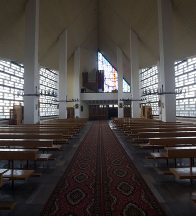 Zdjęcie nr 8: Budynek złożony z dwóch stopionych ze sobą brył, niższej o dwuspadowym dachu nakrywającym wnętrze prezbiterium i nawy oraz ostrosłupa wieży wpisanego w fasadę. Od strony prezbiterium dostawiona nieregularna bryła, niższa od kościoła, nakryta dwuspadowym dachem, mieszcząca zakrystię i kaplice Matki Boskiej. Połać dwustadowego dachu o nieregularnym, zygzakowatym konturze krawędzi, odsłaniającej przeszklone ściany, a miejscami sięgająca ziemi. Trójkątna w przekroju fasada z wieżą wpisaną w jej prawą połowę; lewa zaś w górnej połowie wypełniona witrażem, zamkniętym u dołu balkonem, nakrywającym przedsionek z wejściem do świątyni. Zewnętrzne elewacje kościoła pokryte są okładziną z wapienia pińczowskiego

Trójkątne w przekroju wnętrze podzielone na trzy nawy filarami. Prezbiterium zamknięte ścianą z wydzielonym trójkątem ołtarza głównego, złożonego z dwóch ścian pokrytych okładziną ceramiczną ustawionych pod kątem rozwartym, z otworem u szczytu na okno. Po przeciwnej stronie wnętrza wejście na wieżę i parapet chóru muzycznego. Na zakończeniu lewej nawy wejście do kaplicy Matki Boskiej, na zakończeniu prawej nawy zaaranżowana kaplica bł. Anieli Salawy. Ściany boczne całkowicie przeszklone; połowę przestrzeni fasady wypełnia witraż o polu w formie trójkąta o kącie prostym. W kaplicy Matki Boskiej otwory w formie szczelin oświetlające wnętrze umieszczone nieregularnie w polu ściany. 




