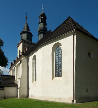 Zdjęcie nr 4: Kościół murowany z kamienia, z użyciem cegły, tynkowany; orientowany, jednonawowy. Prezbiterium węższe od nawy, zwężające się, na rzucie zbliżonym do trapezu. Przy północnej ścianie zakrystia w rzucie zbliżonym do kwadratu, z ukośną ścianą południową. Nawa na planie prostokąta, z przylegającymi od południa kruchtą i wieżą od zachodu na rzucie prostokąta. Nawa i zakrystia opięte szkarpami. 
Wnętrze nakryte stropami drewnianymi. Wątki ceglane i murowane ścian odsłonięte. Zamiast posadzki wylewka betonowa (posadzki kamienne zdemontowane). Otwór tęczowy półkolisty. Otwory okienne nawy i prezbiterium w liczbie czterech na południowej ścianie i jednego na północnej w części prezbiterium; w formie wydłużonego stojącego prostokąta zamkniętego półkoliście ze ściętymi glifami, bez obramień. Na ścianie zamykającej prezbiterium niewielki okulus. Na ścianie zachodniej niewielkie otwory okienne w formie stojącego prostokąta, dwa zamknięte ostrołukowo (przesłonięte), jeden zamknięty łukiem odcinkowym oraz dwa okulusy (zamurowane). Otwory okienne wieży ostrołukowe, z profilowanymi obramieniami kamiennymi. W zakrystii małe kwadratowe okienko przesłonięte kratownicą. Otwory drzwiowe: w wejściu do przyziemia wieży od zachodu, otwór w formie stojącego prostokąta zamkniętego łukiem ostrym, w kamiennym obramieniu zwieńczony kamienną tablicą (z datą budowy wieży „1868”), z drewnianymi drzwiami płycinowymi, dwuskrzydłowymi; w przejściu z przyziemia wieży do nawy otwór w formie stojącego prostokąta zamkniętego półkoliście (pierwotnie zamkniętego łukiem odcinkowym), przesłonięty metalową kratą; w wejściu do kruchty południowej otwór w formie stojącego prostokąta zamknięty łukiem odcinkowym, z drzwiami płycinowymi, dwuskrzydłowymi; w przejściu z kruchty do nawy otwór w formie stojącego prostokąta zamknięty półkoliście z drewnianymi drzwiami z okuciami, zamkiem i antabą; w wejściu do zakrystii od zewnętrz otwór prostokątny, z drzwiami jednoskrzydłowymi, płycinowymi; w przejściu z zakrystii do nawy otwór w formie stojącego prostokąta, w kamiennym obramieniu, z drzwiami z okuciami i zamkiem. Elewacje tynkowane, zamknięte profilowanymi gzymsami podokapowymi. Nawa, zakrystia i kruchta opięte szkarpami (przy nawie uskokowymi z daszkami okapowymi). Fasada zamknięta ceglanym szczytem, dekorowanym schodkowym krenelażem, z dwoma niewielkimi, smukłymi otworami okiennymi zamkniętymi ostrołukowo. 
Wieża trójkondygnacyjna, bez podziałów architektonicznych, druga kondygnacja zamknięta daszkiem okapowym. Zwieńczona dachem namiotowym z latarnią na planie ośmioboku, zamkniętą dachem wieżowym, pobitym blachą.
Pierwotne dachy siodłowe, o odrębnych kalenicach dla nawy i prezbiterium, kryte gontem; więźba drewniana, konstrukcji krokwiowej. Nad nawą wieżyczka na sygnaturkę z hełmem baniastym z latarnią, kryta blachą. Kruchtę przykrywa dach dwuspadowy, kryty gontem. 
