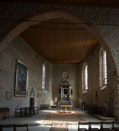 Zdjęcie nr 10: Kościół murowany z kamienia, z użyciem cegły, tynkowany; orientowany, jednonawowy. Prezbiterium węższe od nawy, zwężające się, na rzucie zbliżonym do trapezu. Przy północnej ścianie zakrystia w rzucie zbliżonym do kwadratu, z ukośną ścianą południową. Nawa na planie prostokąta, z przylegającymi od południa kruchtą i wieżą od zachodu na rzucie prostokąta. Nawa i zakrystia opięte szkarpami. 
Wnętrze nakryte stropami drewnianymi. Wątki ceglane i murowane ścian odsłonięte. Zamiast posadzki wylewka betonowa (posadzki kamienne zdemontowane). Otwór tęczowy półkolisty. Otwory okienne nawy i prezbiterium w liczbie czterech na południowej ścianie i jednego na północnej w części prezbiterium; w formie wydłużonego stojącego prostokąta zamkniętego półkoliście ze ściętymi glifami, bez obramień. Na ścianie zamykającej prezbiterium niewielki okulus. Na ścianie zachodniej niewielkie otwory okienne w formie stojącego prostokąta, dwa zamknięte ostrołukowo (przesłonięte), jeden zamknięty łukiem odcinkowym oraz dwa okulusy (zamurowane). Otwory okienne wieży ostrołukowe, z profilowanymi obramieniami kamiennymi. W zakrystii małe kwadratowe okienko przesłonięte kratownicą. Otwory drzwiowe: w wejściu do przyziemia wieży od zachodu, otwór w formie stojącego prostokąta zamkniętego łukiem ostrym, w kamiennym obramieniu zwieńczony kamienną tablicą (z datą budowy wieży „1868”), z drewnianymi drzwiami płycinowymi, dwuskrzydłowymi; w przejściu z przyziemia wieży do nawy otwór w formie stojącego prostokąta zamkniętego półkoliście (pierwotnie zamkniętego łukiem odcinkowym), przesłonięty metalową kratą; w wejściu do kruchty południowej otwór w formie stojącego prostokąta zamknięty łukiem odcinkowym, z drzwiami płycinowymi, dwuskrzydłowymi; w przejściu z kruchty do nawy otwór w formie stojącego prostokąta zamknięty półkoliście z drewnianymi drzwiami z okuciami, zamkiem i antabą; w wejściu do zakrystii od zewnętrz otwór prostokątny, z drzwiami jednoskrzydłowymi, płycinowymi; w przejściu z zakrystii do nawy otwór w formie stojącego prostokąta, w kamiennym obramieniu, z drzwiami z okuciami i zamkiem. Elewacje tynkowane, zamknięte profilowanymi gzymsami podokapowymi. Nawa, zakrystia i kruchta opięte szkarpami (przy nawie uskokowymi z daszkami okapowymi). Fasada zamknięta ceglanym szczytem, dekorowanym schodkowym krenelażem, z dwoma niewielkimi, smukłymi otworami okiennymi zamkniętymi ostrołukowo. 
Wieża trójkondygnacyjna, bez podziałów architektonicznych, druga kondygnacja zamknięta daszkiem okapowym. Zwieńczona dachem namiotowym z latarnią na planie ośmioboku, zamkniętą dachem wieżowym, pobitym blachą.
Pierwotne dachy siodłowe, o odrębnych kalenicach dla nawy i prezbiterium, kryte gontem; więźba drewniana, konstrukcji krokwiowej. Nad nawą wieżyczka na sygnaturkę z hełmem baniastym z latarnią, kryta blachą. Kruchtę przykrywa dach dwuspadowy, kryty gontem. 
