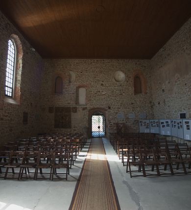 Zdjęcie nr 14: Kościół murowany z kamienia, z użyciem cegły, tynkowany; orientowany, jednonawowy. Prezbiterium węższe od nawy, zwężające się, na rzucie zbliżonym do trapezu. Przy północnej ścianie zakrystia w rzucie zbliżonym do kwadratu, z ukośną ścianą południową. Nawa na planie prostokąta, z przylegającymi od południa kruchtą i wieżą od zachodu na rzucie prostokąta. Nawa i zakrystia opięte szkarpami. 
Wnętrze nakryte stropami drewnianymi. Wątki ceglane i murowane ścian odsłonięte. Zamiast posadzki wylewka betonowa (posadzki kamienne zdemontowane). Otwór tęczowy półkolisty. Otwory okienne nawy i prezbiterium w liczbie czterech na południowej ścianie i jednego na północnej w części prezbiterium; w formie wydłużonego stojącego prostokąta zamkniętego półkoliście ze ściętymi glifami, bez obramień. Na ścianie zamykającej prezbiterium niewielki okulus. Na ścianie zachodniej niewielkie otwory okienne w formie stojącego prostokąta, dwa zamknięte ostrołukowo (przesłonięte), jeden zamknięty łukiem odcinkowym oraz dwa okulusy (zamurowane). Otwory okienne wieży ostrołukowe, z profilowanymi obramieniami kamiennymi. W zakrystii małe kwadratowe okienko przesłonięte kratownicą. Otwory drzwiowe: w wejściu do przyziemia wieży od zachodu, otwór w formie stojącego prostokąta zamkniętego łukiem ostrym, w kamiennym obramieniu zwieńczony kamienną tablicą (z datą budowy wieży „1868”), z drewnianymi drzwiami płycinowymi, dwuskrzydłowymi; w przejściu z przyziemia wieży do nawy otwór w formie stojącego prostokąta zamkniętego półkoliście (pierwotnie zamkniętego łukiem odcinkowym), przesłonięty metalową kratą; w wejściu do kruchty południowej otwór w formie stojącego prostokąta zamknięty łukiem odcinkowym, z drzwiami płycinowymi, dwuskrzydłowymi; w przejściu z kruchty do nawy otwór w formie stojącego prostokąta zamknięty półkoliście z drewnianymi drzwiami z okuciami, zamkiem i antabą; w wejściu do zakrystii od zewnętrz otwór prostokątny, z drzwiami jednoskrzydłowymi, płycinowymi; w przejściu z zakrystii do nawy otwór w formie stojącego prostokąta, w kamiennym obramieniu, z drzwiami z okuciami i zamkiem. Elewacje tynkowane, zamknięte profilowanymi gzymsami podokapowymi. Nawa, zakrystia i kruchta opięte szkarpami (przy nawie uskokowymi z daszkami okapowymi). Fasada zamknięta ceglanym szczytem, dekorowanym schodkowym krenelażem, z dwoma niewielkimi, smukłymi otworami okiennymi zamkniętymi ostrołukowo. 
Wieża trójkondygnacyjna, bez podziałów architektonicznych, druga kondygnacja zamknięta daszkiem okapowym. Zwieńczona dachem namiotowym z latarnią na planie ośmioboku, zamkniętą dachem wieżowym, pobitym blachą.
Pierwotne dachy siodłowe, o odrębnych kalenicach dla nawy i prezbiterium, kryte gontem; więźba drewniana, konstrukcji krokwiowej. Nad nawą wieżyczka na sygnaturkę z hełmem baniastym z latarnią, kryta blachą. Kruchtę przykrywa dach dwuspadowy, kryty gontem. 
