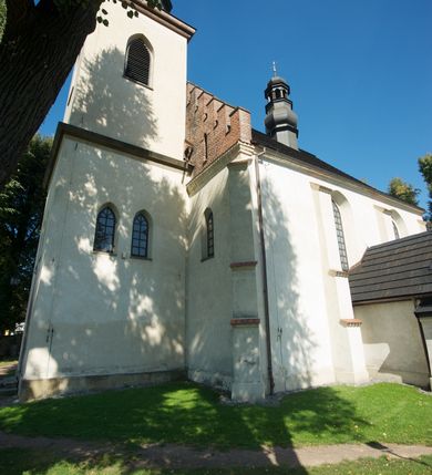 Zdjęcie nr 19: Kościół murowany z kamienia, z użyciem cegły, tynkowany; orientowany, jednonawowy. Prezbiterium węższe od nawy, zwężające się, na rzucie zbliżonym do trapezu. Przy północnej ścianie zakrystia w rzucie zbliżonym do kwadratu, z ukośną ścianą południową. Nawa na planie prostokąta, z przylegającymi od południa kruchtą i wieżą od zachodu na rzucie prostokąta. Nawa i zakrystia opięte szkarpami. 
Wnętrze nakryte stropami drewnianymi. Wątki ceglane i murowane ścian odsłonięte. Zamiast posadzki wylewka betonowa (posadzki kamienne zdemontowane). Otwór tęczowy półkolisty. Otwory okienne nawy i prezbiterium w liczbie czterech na południowej ścianie i jednego na północnej w części prezbiterium; w formie wydłużonego stojącego prostokąta zamkniętego półkoliście ze ściętymi glifami, bez obramień. Na ścianie zamykającej prezbiterium niewielki okulus. Na ścianie zachodniej niewielkie otwory okienne w formie stojącego prostokąta, dwa zamknięte ostrołukowo (przesłonięte), jeden zamknięty łukiem odcinkowym oraz dwa okulusy (zamurowane). Otwory okienne wieży ostrołukowe, z profilowanymi obramieniami kamiennymi. W zakrystii małe kwadratowe okienko przesłonięte kratownicą. Otwory drzwiowe: w wejściu do przyziemia wieży od zachodu, otwór w formie stojącego prostokąta zamkniętego łukiem ostrym, w kamiennym obramieniu zwieńczony kamienną tablicą (z datą budowy wieży „1868”), z drewnianymi drzwiami płycinowymi, dwuskrzydłowymi; w przejściu z przyziemia wieży do nawy otwór w formie stojącego prostokąta zamkniętego półkoliście (pierwotnie zamkniętego łukiem odcinkowym), przesłonięty metalową kratą; w wejściu do kruchty południowej otwór w formie stojącego prostokąta zamknięty łukiem odcinkowym, z drzwiami płycinowymi, dwuskrzydłowymi; w przejściu z kruchty do nawy otwór w formie stojącego prostokąta zamknięty półkoliście z drewnianymi drzwiami z okuciami, zamkiem i antabą; w wejściu do zakrystii od zewnętrz otwór prostokątny, z drzwiami jednoskrzydłowymi, płycinowymi; w przejściu z zakrystii do nawy otwór w formie stojącego prostokąta, w kamiennym obramieniu, z drzwiami z okuciami i zamkiem. Elewacje tynkowane, zamknięte profilowanymi gzymsami podokapowymi. Nawa, zakrystia i kruchta opięte szkarpami (przy nawie uskokowymi z daszkami okapowymi). Fasada zamknięta ceglanym szczytem, dekorowanym schodkowym krenelażem, z dwoma niewielkimi, smukłymi otworami okiennymi zamkniętymi ostrołukowo. 
Wieża trójkondygnacyjna, bez podziałów architektonicznych, druga kondygnacja zamknięta daszkiem okapowym. Zwieńczona dachem namiotowym z latarnią na planie ośmioboku, zamkniętą dachem wieżowym, pobitym blachą.
Pierwotne dachy siodłowe, o odrębnych kalenicach dla nawy i prezbiterium, kryte gontem; więźba drewniana, konstrukcji krokwiowej. Nad nawą wieżyczka na sygnaturkę z hełmem baniastym z latarnią, kryta blachą. Kruchtę przykrywa dach dwuspadowy, kryty gontem. 
