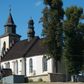Zdjęcie nr 1: Kościół murowany z kamienia, z użyciem cegły, tynkowany; orientowany, jednonawowy. Prezbiterium węższe od nawy, zwężające się, na rzucie zbliżonym do trapezu. Przy północnej ścianie zakrystia w rzucie zbliżonym do kwadratu, z ukośną ścianą południową. Nawa na planie prostokąta, z przylegającymi od południa kruchtą i wieżą od zachodu na rzucie prostokąta. Nawa i zakrystia opięte szkarpami. 
Wnętrze nakryte stropami drewnianymi. Wątki ceglane i murowane ścian odsłonięte. Zamiast posadzki wylewka betonowa (posadzki kamienne zdemontowane). Otwór tęczowy półkolisty. Otwory okienne nawy i prezbiterium w liczbie czterech na południowej ścianie i jednego na północnej w części prezbiterium; w formie wydłużonego stojącego prostokąta zamkniętego półkoliście ze ściętymi glifami, bez obramień. Na ścianie zamykającej prezbiterium niewielki okulus. Na ścianie zachodniej niewielkie otwory okienne w formie stojącego prostokąta, dwa zamknięte ostrołukowo (przesłonięte), jeden zamknięty łukiem odcinkowym oraz dwa okulusy (zamurowane). Otwory okienne wieży ostrołukowe, z profilowanymi obramieniami kamiennymi. W zakrystii małe kwadratowe okienko przesłonięte kratownicą. Otwory drzwiowe: w wejściu do przyziemia wieży od zachodu, otwór w formie stojącego prostokąta zamkniętego łukiem ostrym, w kamiennym obramieniu zwieńczony kamienną tablicą (z datą budowy wieży „1868”), z drewnianymi drzwiami płycinowymi, dwuskrzydłowymi; w przejściu z przyziemia wieży do nawy otwór w formie stojącego prostokąta zamkniętego półkoliście (pierwotnie zamkniętego łukiem odcinkowym), przesłonięty metalową kratą; w wejściu do kruchty południowej otwór w formie stojącego prostokąta zamknięty łukiem odcinkowym, z drzwiami płycinowymi, dwuskrzydłowymi; w przejściu z kruchty do nawy otwór w formie stojącego prostokąta zamknięty półkoliście z drewnianymi drzwiami z okuciami, zamkiem i antabą; w wejściu do zakrystii od zewnętrz otwór prostokątny, z drzwiami jednoskrzydłowymi, płycinowymi; w przejściu z zakrystii do nawy otwór w formie stojącego prostokąta, w kamiennym obramieniu, z drzwiami z okuciami i zamkiem. Elewacje tynkowane, zamknięte profilowanymi gzymsami podokapowymi. Nawa, zakrystia i kruchta opięte szkarpami (przy nawie uskokowymi z daszkami okapowymi). Fasada zamknięta ceglanym szczytem, dekorowanym schodkowym krenelażem, z dwoma niewielkimi, smukłymi otworami okiennymi zamkniętymi ostrołukowo. 
Wieża trójkondygnacyjna, bez podziałów architektonicznych, druga kondygnacja zamknięta daszkiem okapowym. Zwieńczona dachem namiotowym z latarnią na planie ośmioboku, zamkniętą dachem wieżowym, pobitym blachą.
Pierwotne dachy siodłowe, o odrębnych kalenicach dla nawy i prezbiterium, kryte gontem; więźba drewniana, konstrukcji krokwiowej. Nad nawą wieżyczka na sygnaturkę z hełmem baniastym z latarnią, kryta blachą. Kruchtę przykrywa dach dwuspadowy, kryty gontem. 
