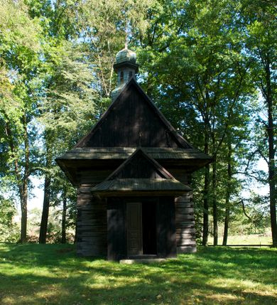 Zdjęcie nr 2: Kościół na podmurówce z kamienia łamanego, konstrukcji zrębowej, z belek o zróżnicowanych przekrojach, wiązanych w węgłach na jaskółczy ogon; orientowany, salowy; kruchta konstrukcji szkieletowej, szalowana deskami.
Kościół na planie prostokąta zamkniętego trójbocznie. Od zachodu dostawiona kwadratowa kruchta-przedsionek. 
Wnętrze nakryte stropem belkowym z deskową podsufitką. Ściany pokryte listwowymi boazeriami. Posadzka kamienna, a w niej umieszczone trzy płyty nagrobne, kamienne. 
Dwa otwory okienne w ścianie południowej i północnej, w formie stojącego prostokąta zamkniętego łukiem odcinkowym, skrzynkowe, obwiedzione listwowymi opaskami, z kwaterowymi podziałami. Otwory wejściowe: w wejściu do przedsionka od zachodu drzwi dwuskrzydłowe, płycinowe w futrynie skrzynkowej; w przejściu do nawy drzwi deskowe-spągowe, dwuskrzydłowe, w odrzwiach belkowych. 
Kościół nakryty dachem siodłowym, jednokalenicowym, dwuspadowym, krytym gontem; o więźbie krokwiowo-siodłowej. Od zachodu nad korpusem i przedsionkiem wydatne daszki okapowe, kryte gontem. Szczyty szalowane deskami w układzie pionowym na styk, z listwowaniem. Nad nawą, na kalenicy wieżyczka na sygnaturkę z wydatnym z hełmem baniastym z latarnią, pobita blachą. 
