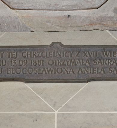 Zdjęcie nr 2: Chrzcielnicą ustawiona na niskiej podstawie na planie kwadratu. Płaszcz stopy na planie ośmioboku, zwężający się ku  górze, zamknięty profilowanym, ośmiobocznym pierścieniem. Trzon o przekroju ośmiobocznym. Czara o przekroju ośmiobocznym, wypukła, z wywiniętym brzegiem, w dolnej części dekorowana imitacją puklowania. 

